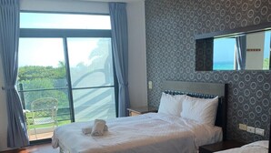 A hotel room with two beds, a large window with curtains, a balcony, and a patterned wall. - Happiness Inn (Hengchun)