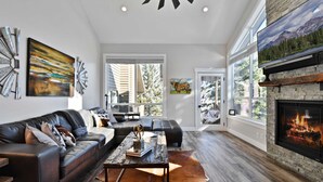 A modern living room with a fireplace, leather sofa, and large windows. - Powder Pointe by AvantStay | Minutes From Base Village (Park City)
