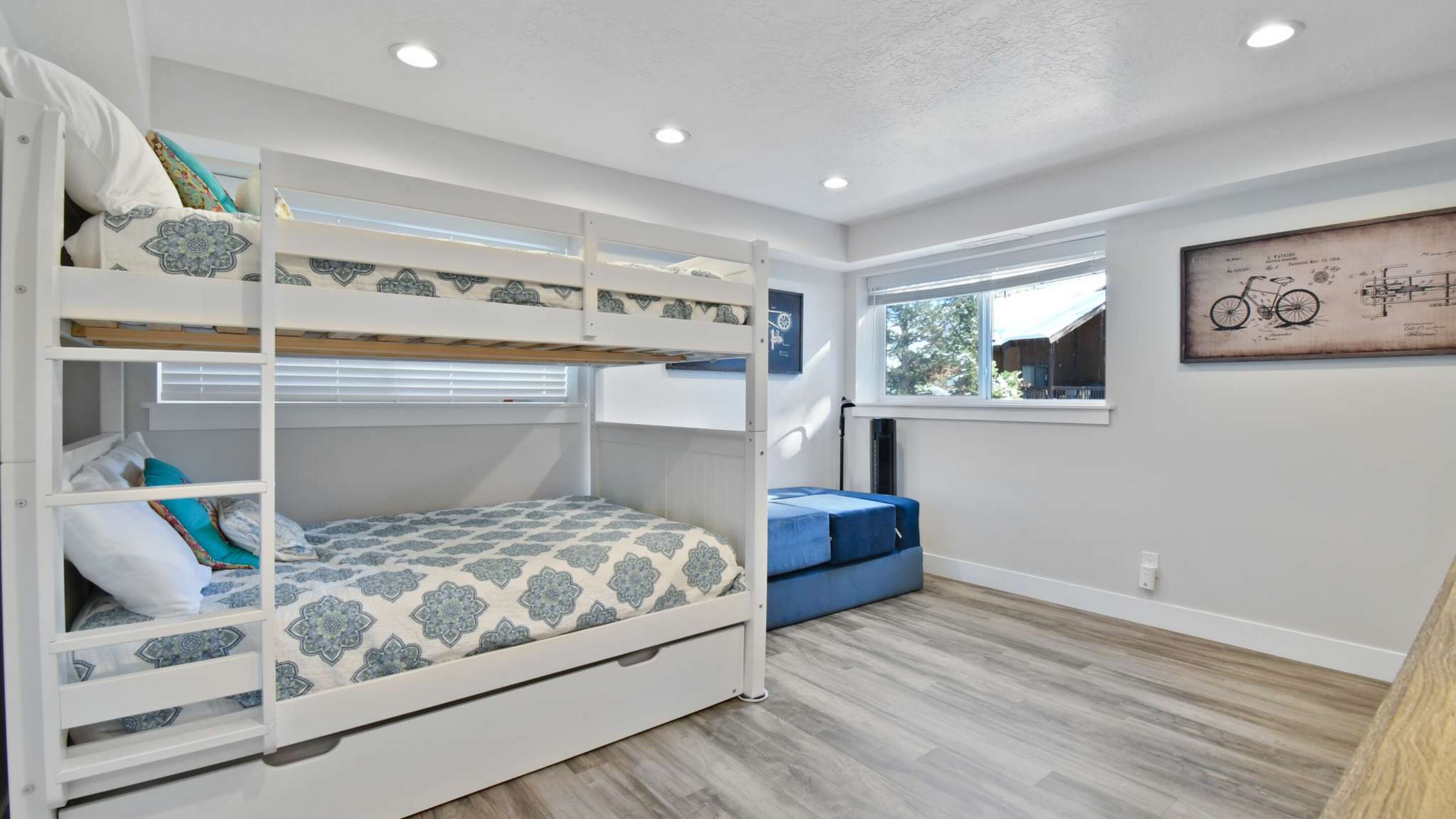 A bunk bed room with a window and a bicycle illustration on the wall.