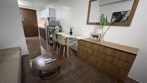 Een kleine keuken met een eethoek, een houten kast en een spiegel.
