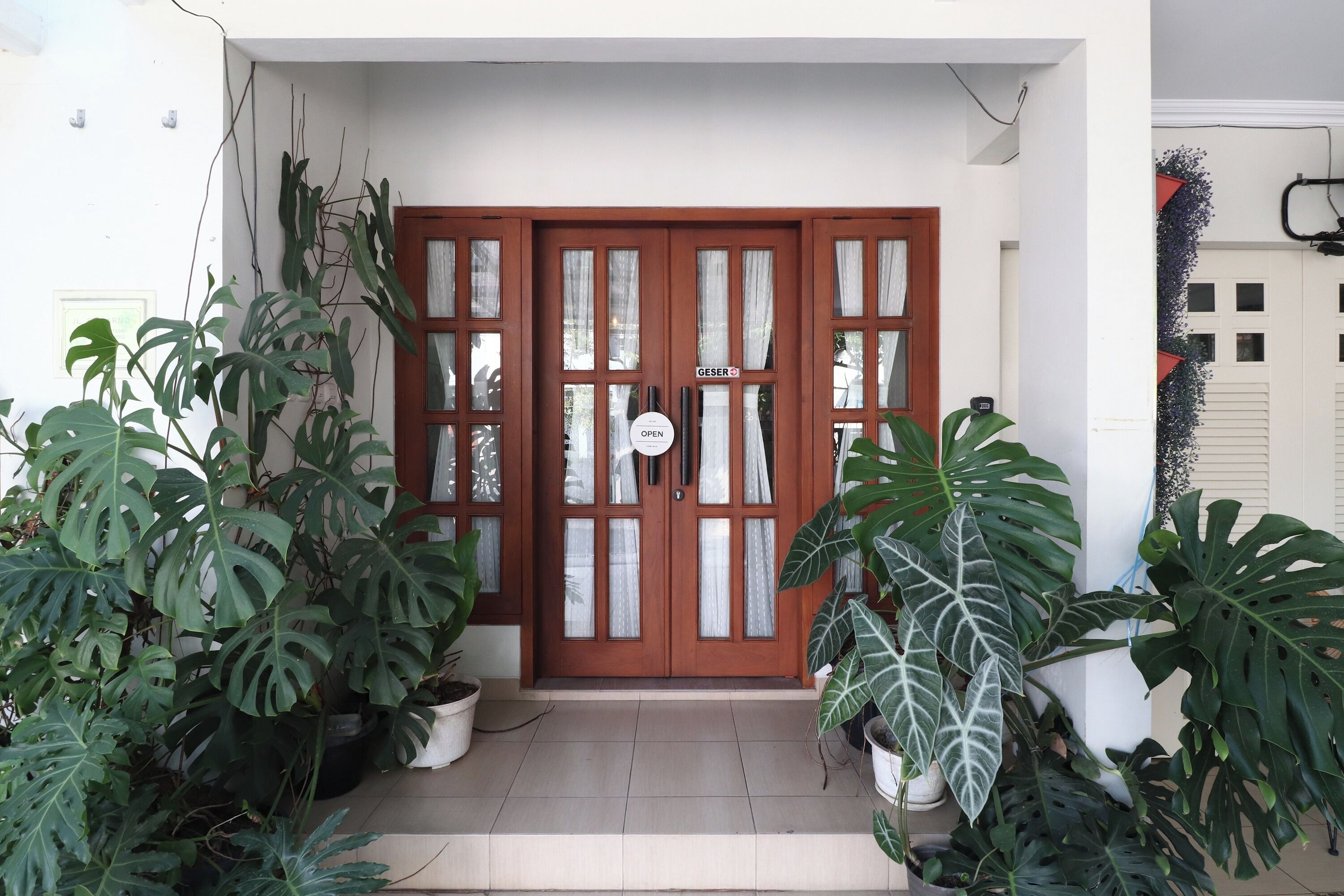 A wooden door with glass panels and a sign indicating the establishment is open.