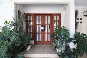 Puerta de madera con paneles de vidrio y un letrero que indica que el establecimiento está abierto.
