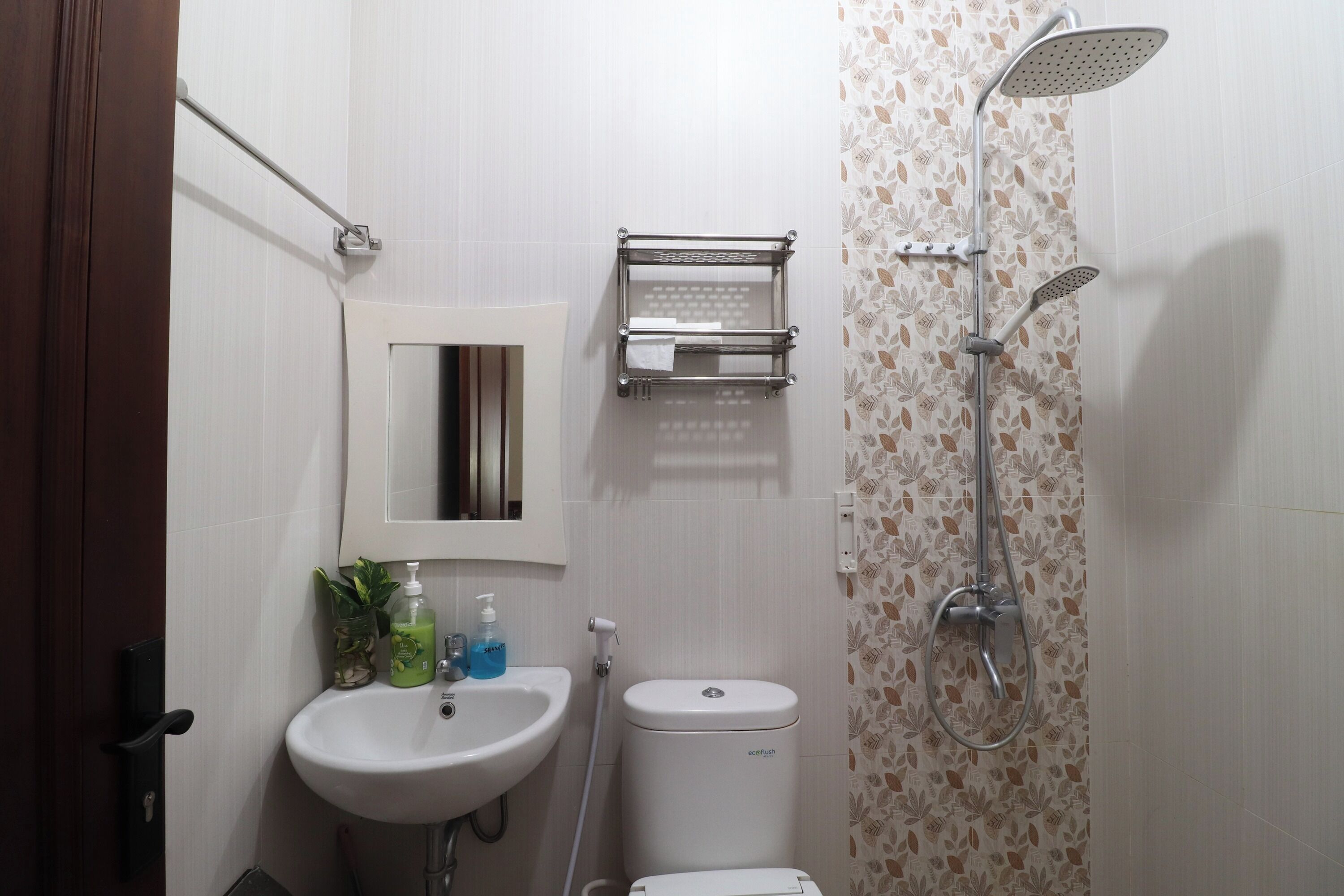A bathroom with a white sink, a toilet, a shower, and a towel rack.