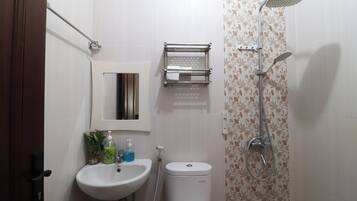 A bathroom with a white sink, a toilet, a shower, and a towel rack.