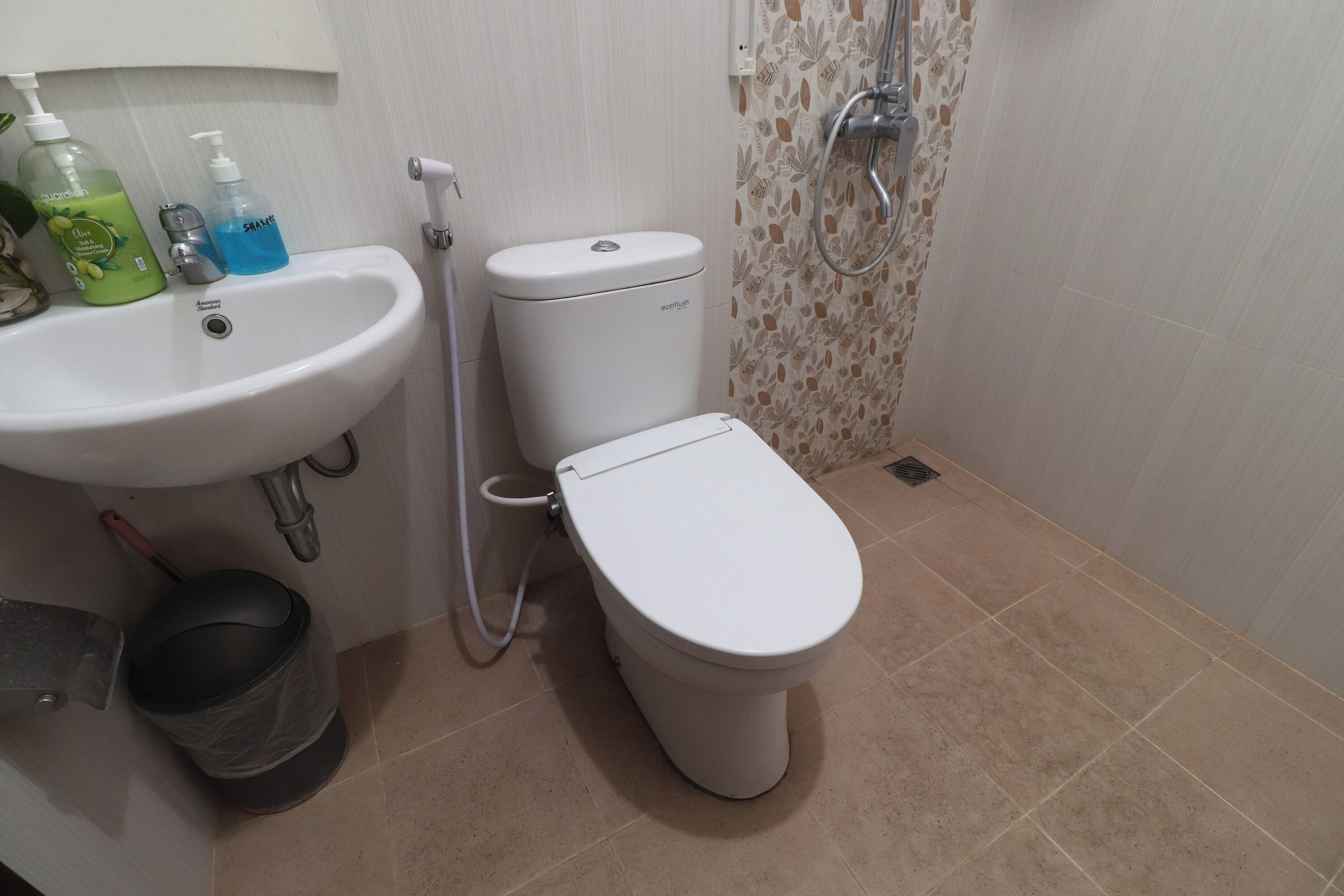 A bathroom with a white sink, toilet, and shower.