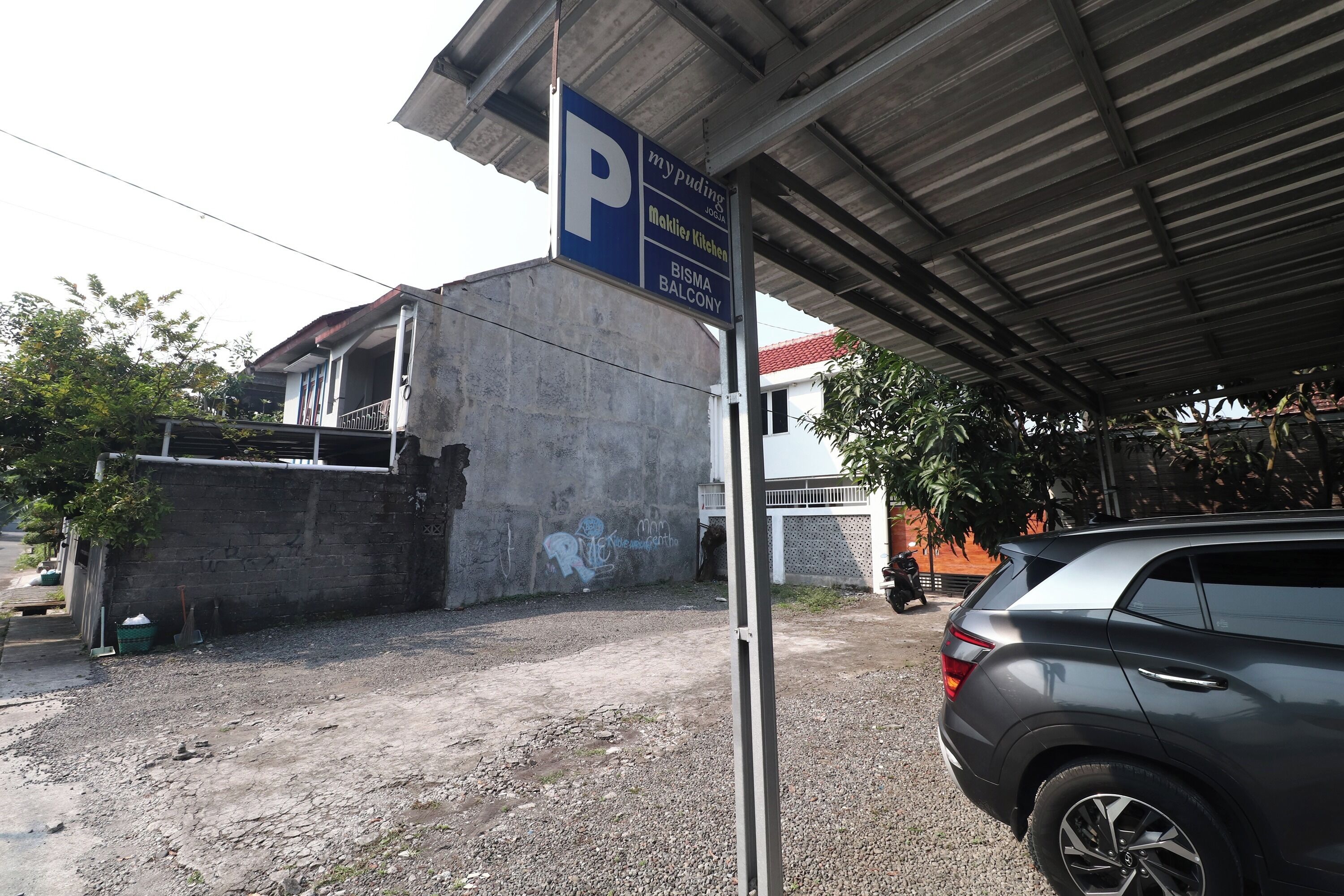 Señal de estacionamiento con un edificio al fondo.