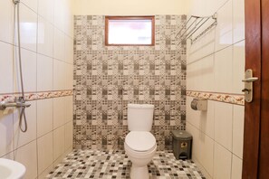 Un baño con inodoro, bidé y ducha.