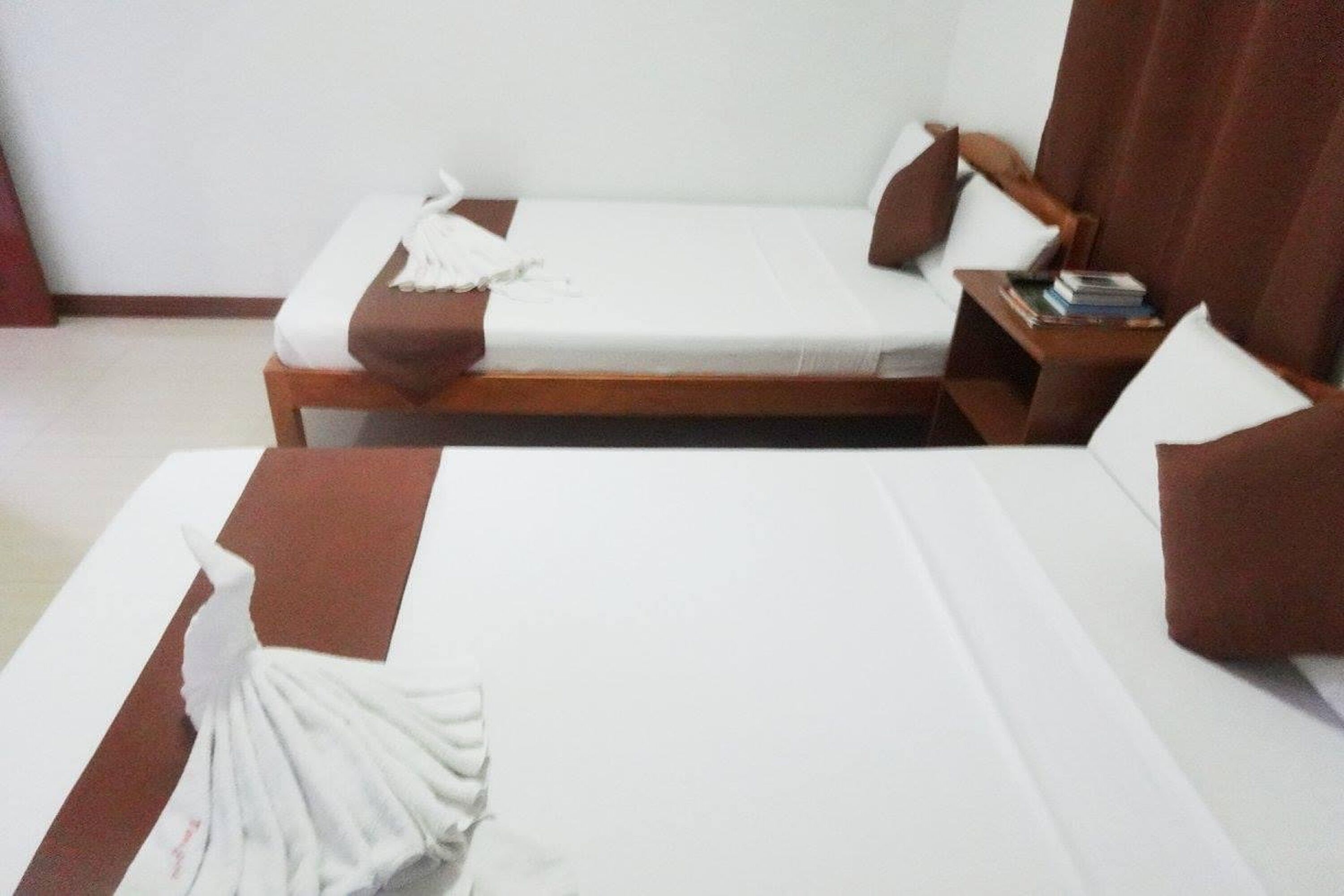 A hotel room with a bed, a nightstand, and a chair.