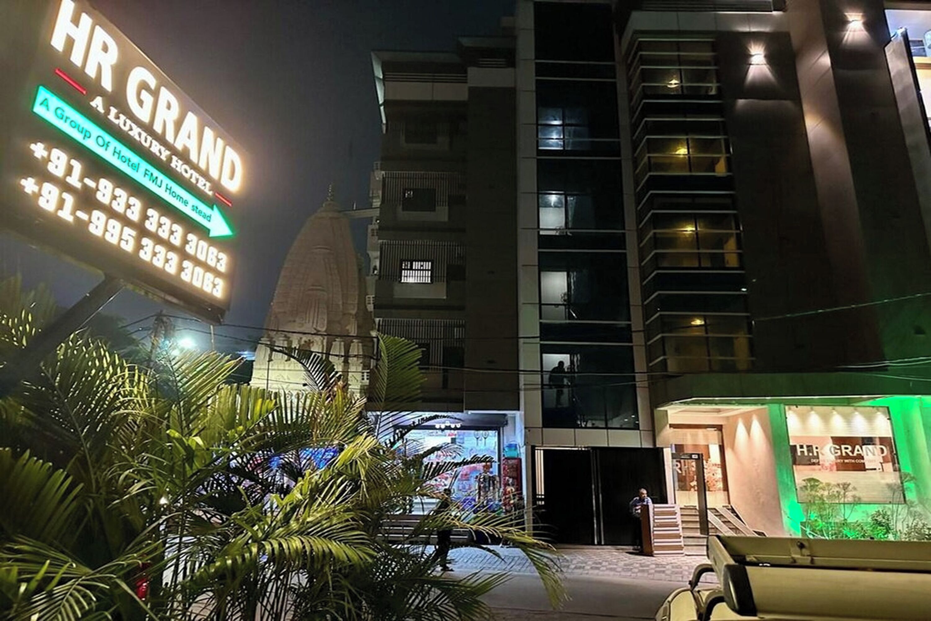 Ein Hotel namens "HR GRAND" mit einer auffälligen, beleuchteten Signatur.