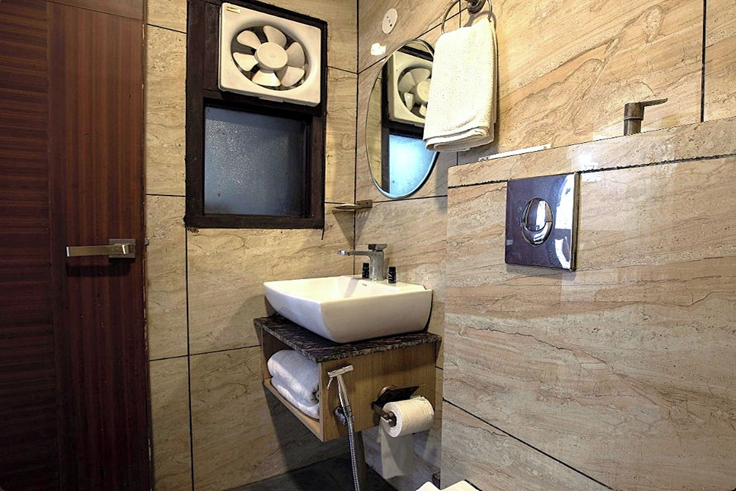 A modern bathroom with a marble sink, towel rack, and a mirror.