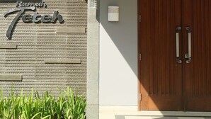 Fachada moderna de un edificio con pared texturizada y puerta de madera.