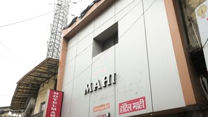 Un edificio con un cartel que indica Hotel Mahi, que ofrece habitaciones con aire acondicionado.