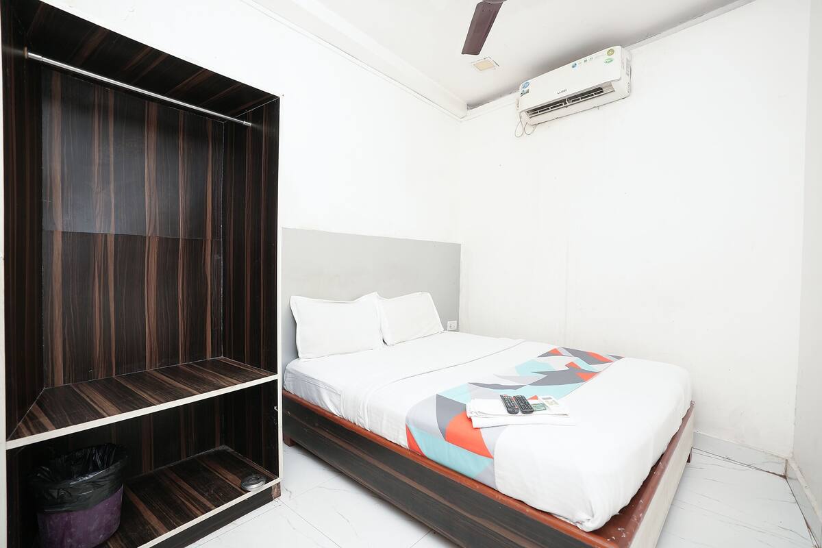 Un dormitorio con cama, armario y aire acondicionado.