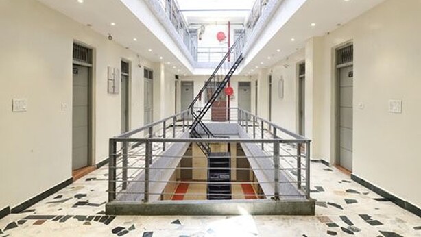 A spacious interior with a central staircase, a skylight, and a patterned floor. - Hotel Amrit Near Old Delhi Railway Station (New Delhi)