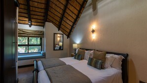 A bedroom with a large bed, a window seat, and a view of greenery outside. - Kruger Park Lodge Unit No. 209 (Mbombela)