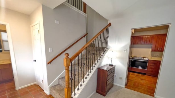 A staircase with wooden handrails and a carpeted landing area. - Two-story, two-bedroom, blocks from Downtown New Braunfels, Comal River, and Texas Tubes (New Braunfels)