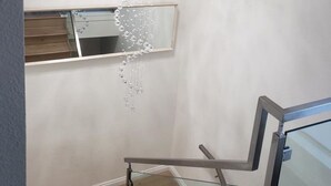 Une salle de bain moderne avec une douche à parois de verre, un luminaire fixé au plafond et un miroir.