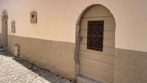 A building with a beige facade, a stone-paved entrance, and a decorative metal door. - Pleasant holiday home in Vrbnik near Secret Beach (Vrbnik)