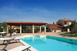 A swimming pool with lounge chairs, a covered patio, and a view of the surrounding landscape. - Villa with private pool in Piancastagnaio (Piancastagnaio)