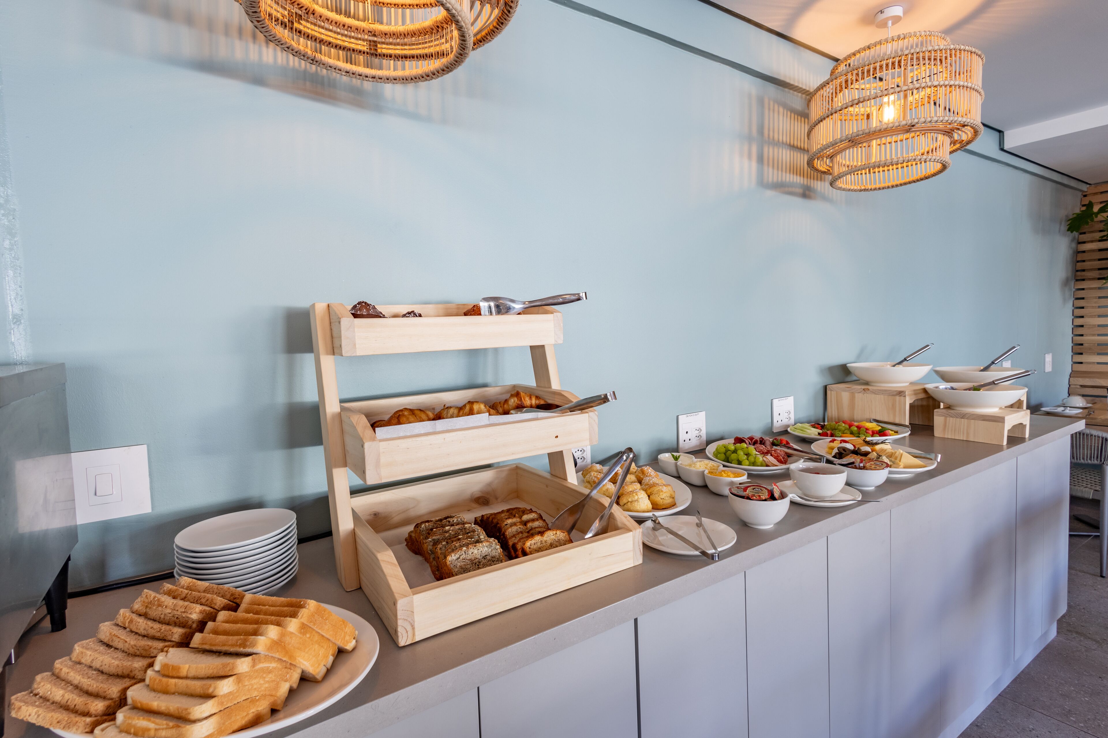 A buffet setup with various food items and wooden serving trays.