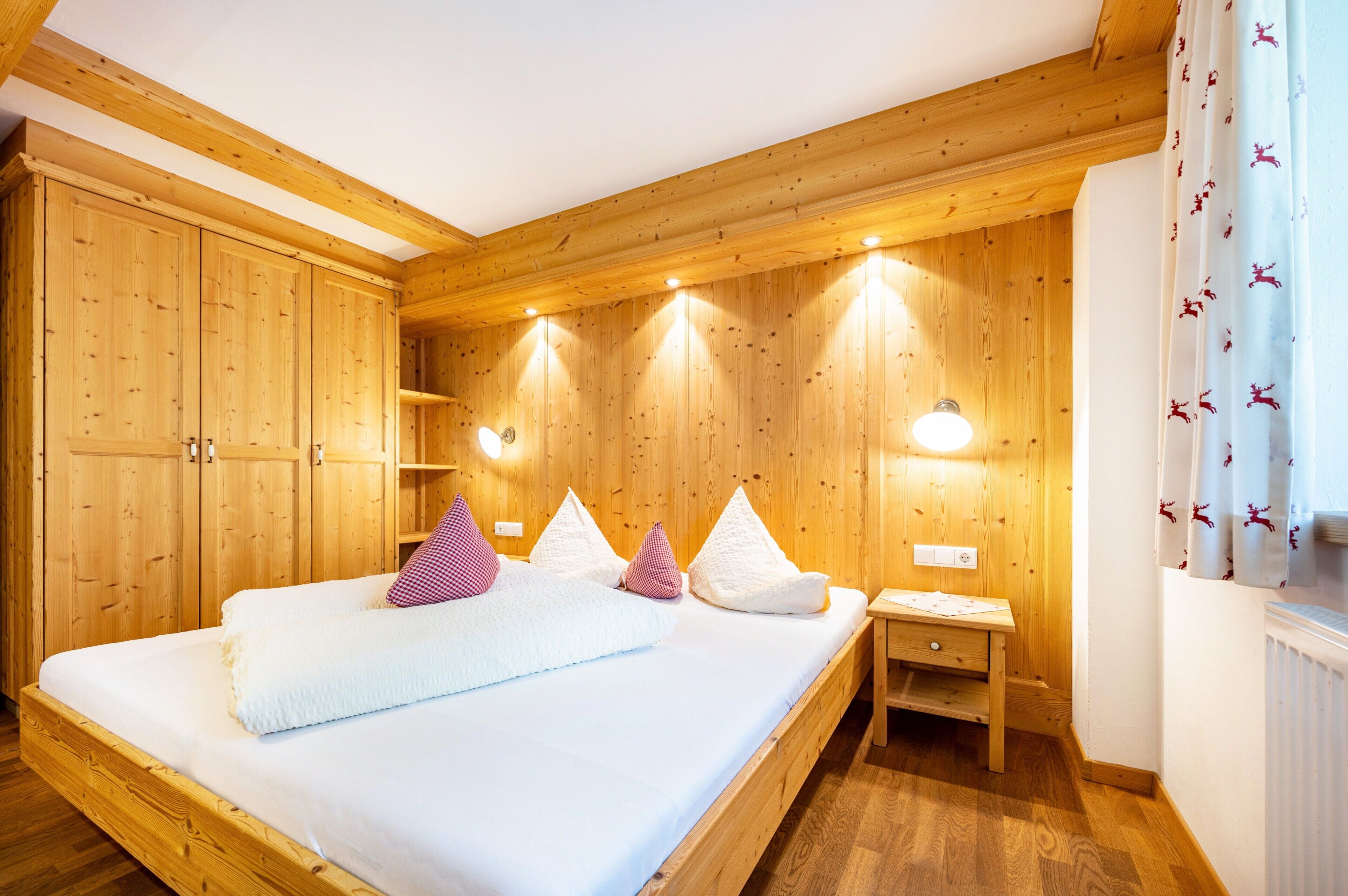 Una stanza con rivestimento in legno, un letto, un comodino e un armadio a muro.