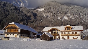 A snow-covered mountain with a chalet-style building in the foreground.