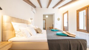 Une chambre à coucher avec un lit, une table de chevet, une fenêtre et une porte.