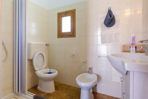 A bathroom with a toilet, bidet, and sink.