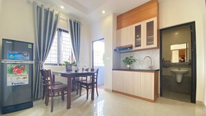 A modern kitchen with a dining area, a built-in oven, and a sink. - Quan Nhan Apartment (Hanoi)