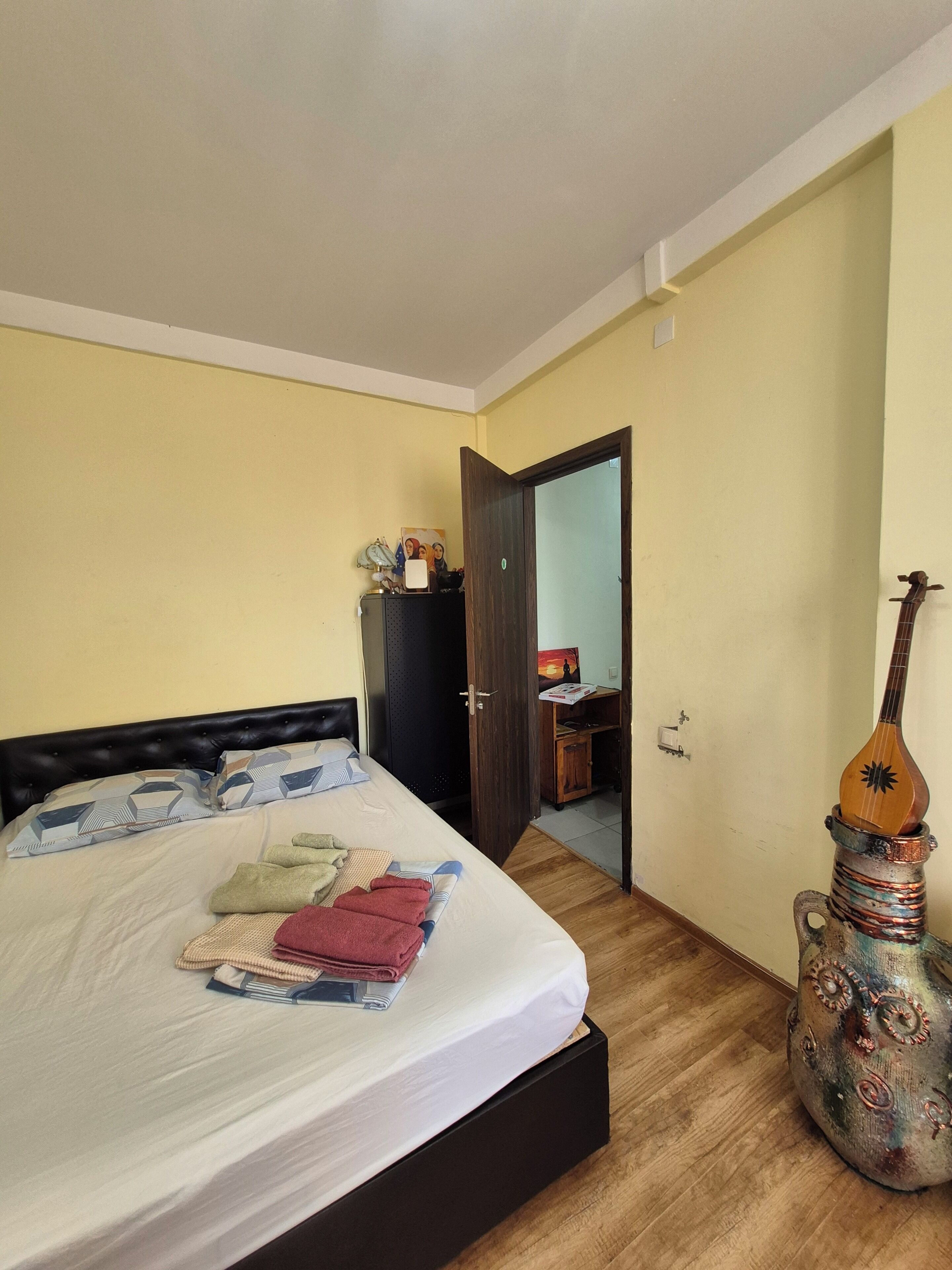Une chambre à coucher avec un lit, une armoire en bois et un objet décoratif.