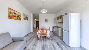 Una cucina moderna con frigorifero bianco, mobili in legno e un'area pranzo con tavolo e sedie.