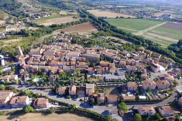 Vista aérea de uma cidade com um conjunto denso de edifícios, estradas e campos verdes.