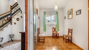 A hallway with a wooden staircase, a window with green curtains, and two wooden chairs. - Country House 'Casa Solariega Con Encanto' with Mountain View, Private Terrace and Wi-Fi (Padul)