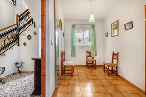 A hallway with a wooden staircase, a window with green curtains, and two wooden chairs. - Country House 'Casa Solariega Con Encanto' with Mountain View, Private Terrace and Wi-Fi (Padul)