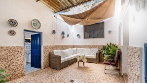 A room with a white sofa, a blue door, and a tiled floor. - Country House 'Casa Solariega Con Encanto' with Mountain View, Private Terrace and Wi-Fi (Padul)