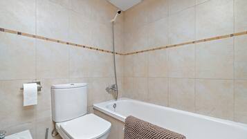 Un baño con inodoro, lavabo y bañera.