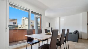 Un'area pranzo moderna con un tavolo grande, sei sedie e un divano.