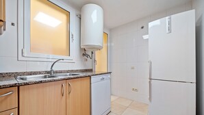 Una cucina con lavello, lavastoviglie e frigorifero.