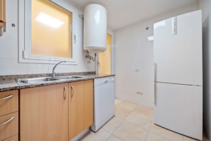 A kitchen with a sink, dishwasher, and refrigerator. - Apartment 'Sara' with Private Terrace, Wi-Fi and Air Conditioning (L'Aldea)