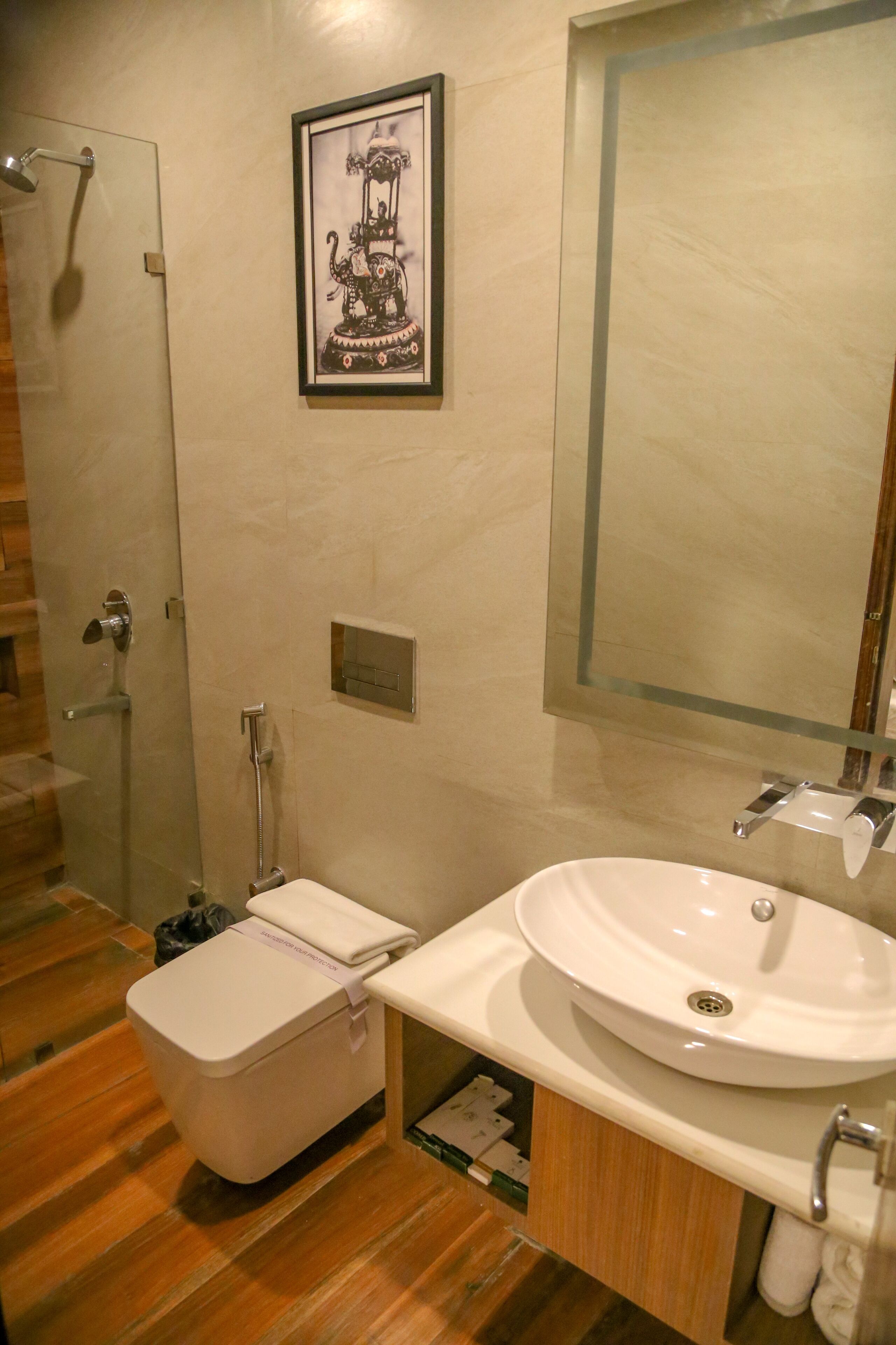 Bagno con WC, lavabo e doccia. C'è un quadro appeso al muro.