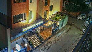 Um hotel de vários andares com design moderno, apresentando uma entrada no nível do solo com balcão de recepção e uma escadaria que leva aos andares superiores.