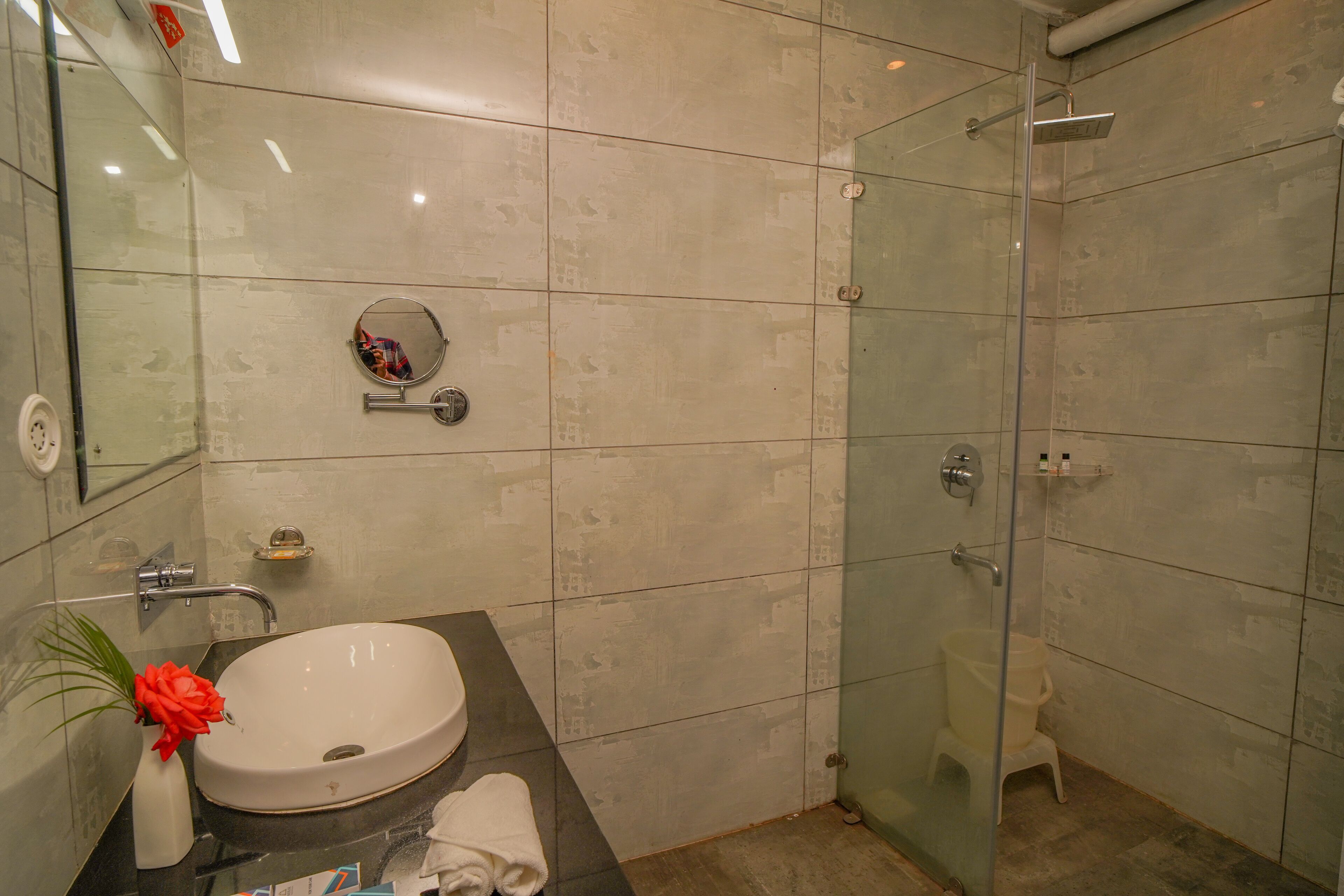 Une salle de bain moderne avec une douche à parois de verre, un lavabo blanc et un miroir.