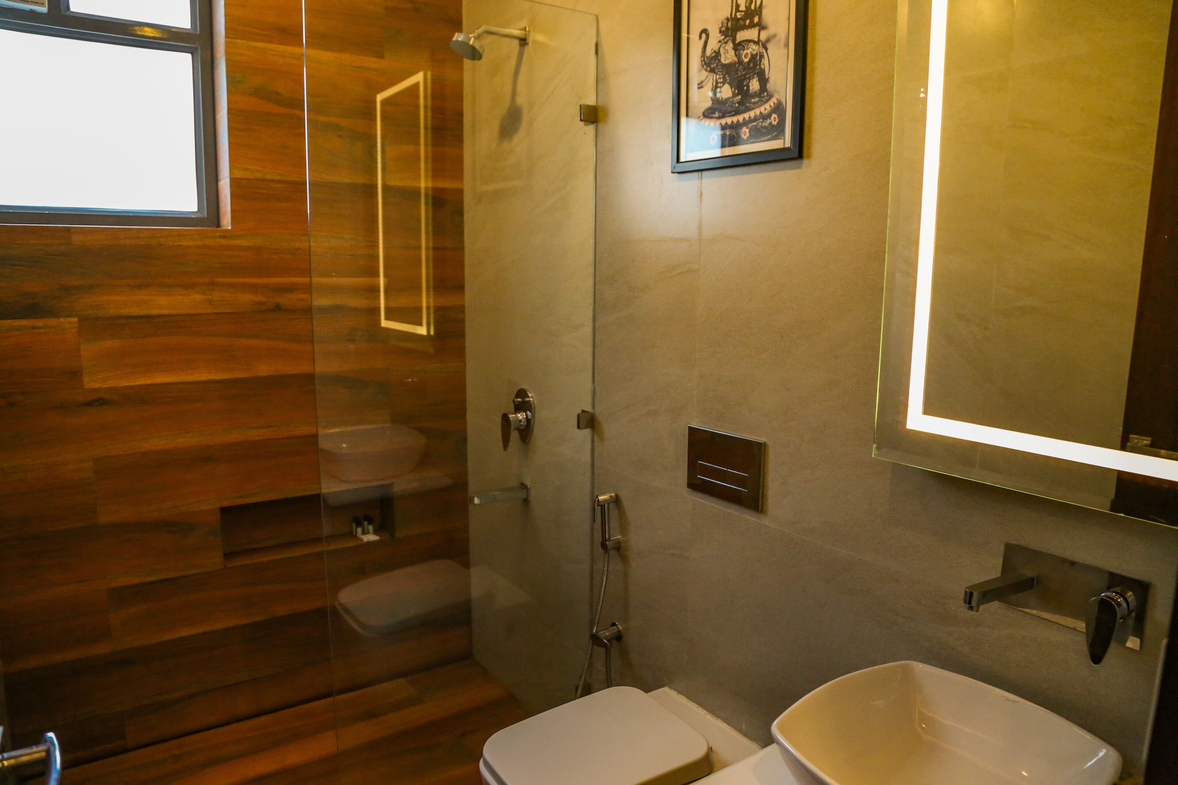 A modern bathroom with a glass shower enclosure, a toilet, and a sink.