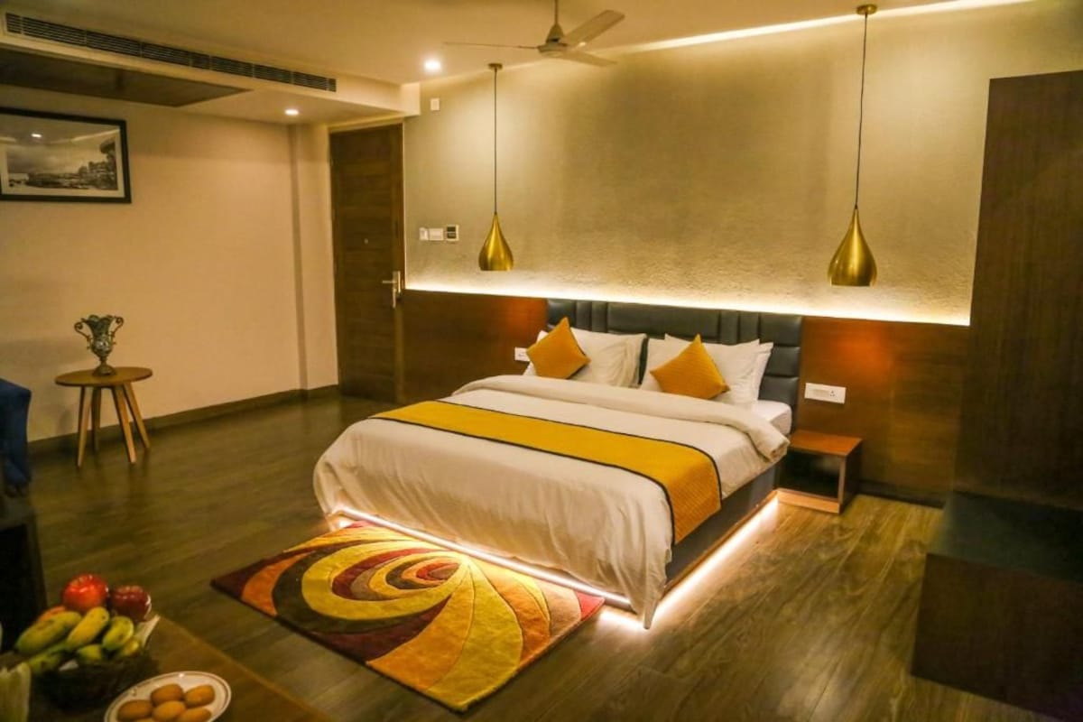 Ein modernes Hotelzimmer mit einem großen Bett, Nachttischen, einem Deckenventilator und einem dekorativen Teppich.