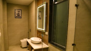 Casa de banho moderna com um espelho grande, uma pia branca e cabine de duche.