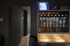 Baarialue, jossa on digitaalinen näyttö, valikoima pulloja ja lasivitriini.