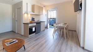 Una cucina moderna con zona pranzo, una TV a parete e vista sull'esterno.
