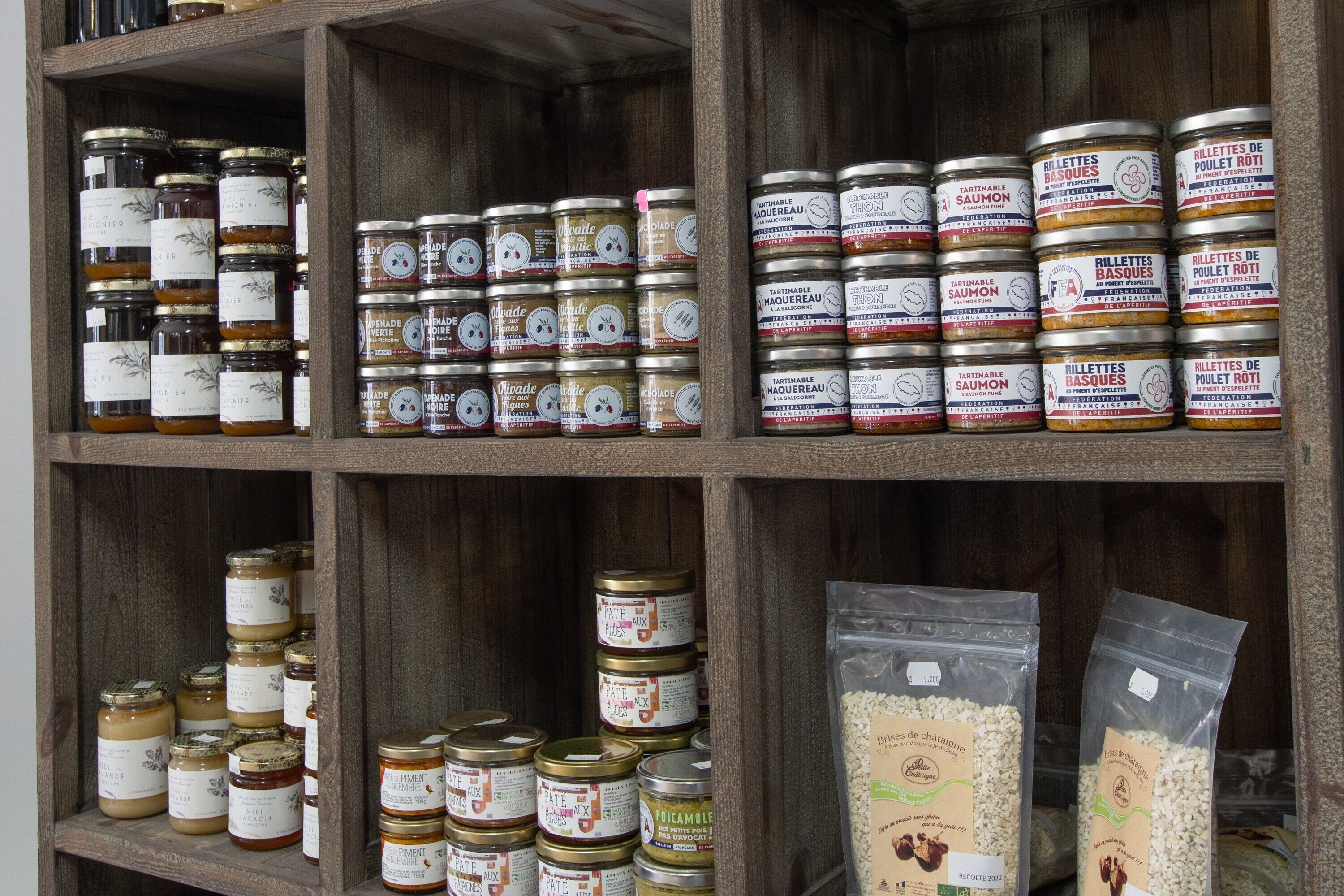 Prestatge de fusta amb diversos aliments, com pots i llaunes.