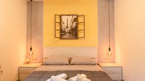 Een slaapkamer met een bed, twee nachtkastjes, een hoofdbord en een aan de muur hangend schilderij.