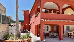 Een rood gebouw met een terras, zitplaatsen buiten en een bord waarop 'LICA' staat.